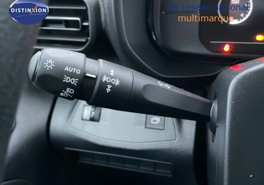 Gros plan sur la manette de commande des feux à gauche du volant dans un Citroën Berlingo Van XL noir Perla Metal 2025.