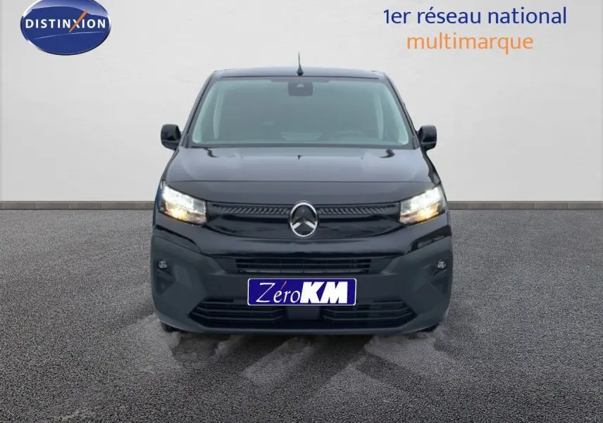 Vue frontale d'un Citroën Berlingo Van XL noir Perla Metal avec phares allumés sur sol goudronné.