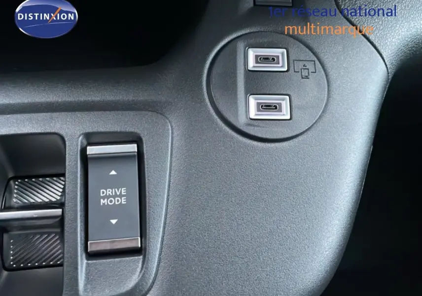 Gros plan sur la console centrale noire du Citroën Berlingo 2025, montrant les ports USB-C et le bouton Drive Mode.