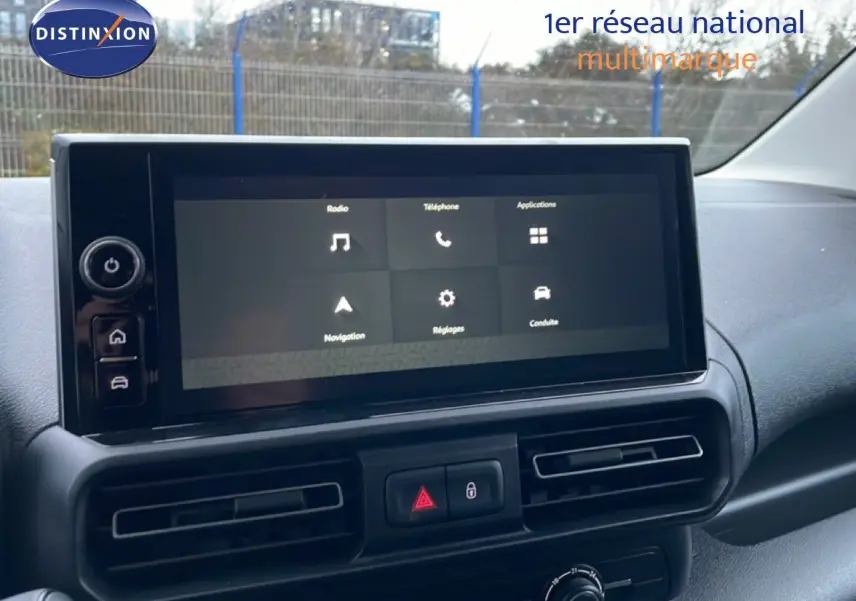 Écran tactile central du tableau de bord du Citroën Berlingo 2025, avec commandes de navigation et climatisation visibles.