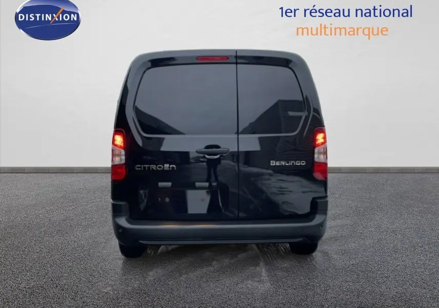 Vue arrière d’un Citroën Berlingo Van XL noir Perla Metal avec feux allumés sur fond neutre.