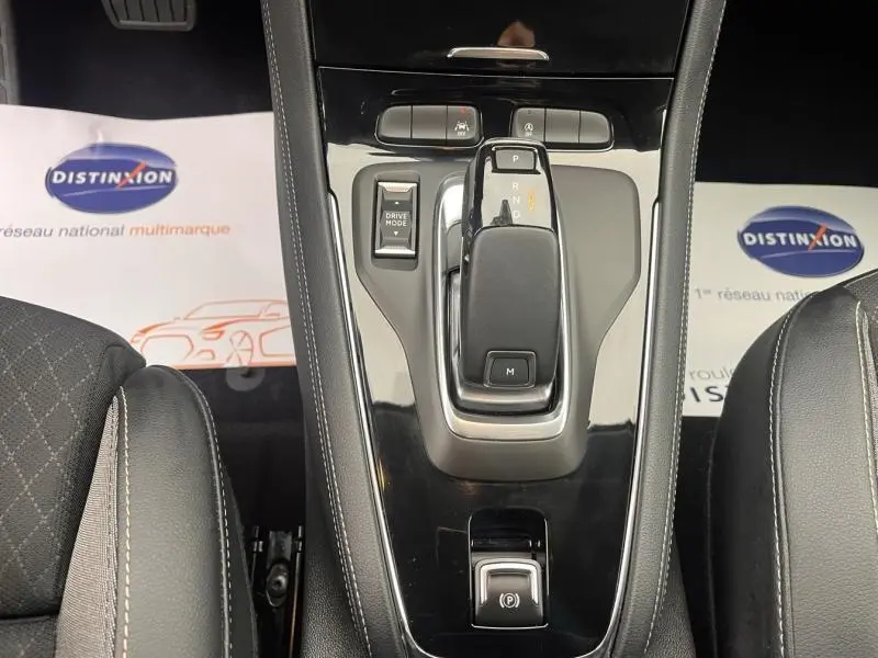 Vue rapprochée de la console centrale noire brillante avec levier de vitesses automatique et accoudoirs en cuir gris du Opel Grandland 2023.