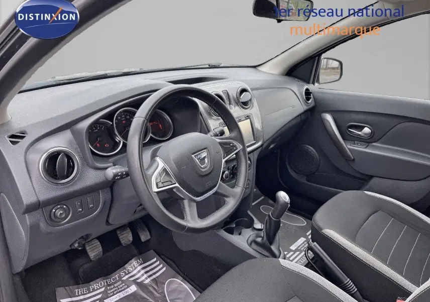 Intérieur de la Dacia Sandero Stepway 2016 en gris foncé, vue côté conducteur montrant le tableau de bord et volant.