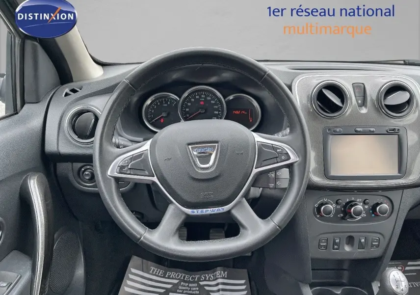 Vue intérieure frontale du volant et tableau de bord gris foncé de la Dacia Sandero Stepway 2016 essence.