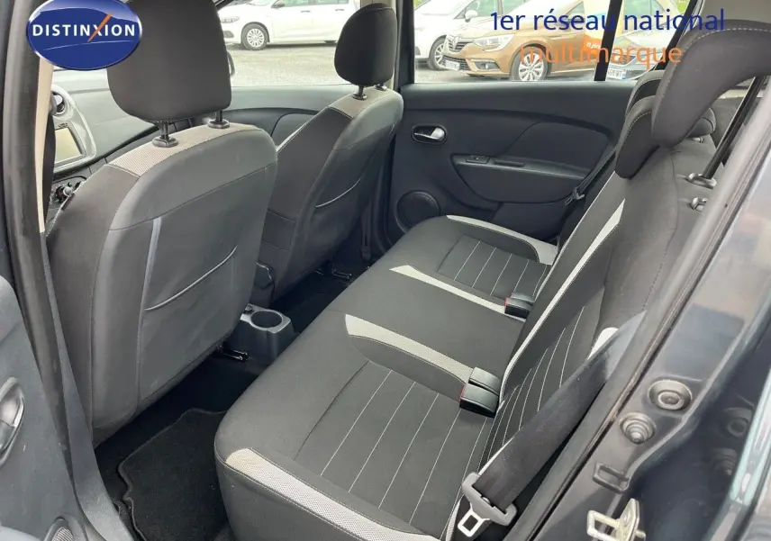 Vue intérieure arrière côté droit de la Dacia Sandero Stepway 2016 gris foncé, montrant les sièges arrière en tissu bicolore.