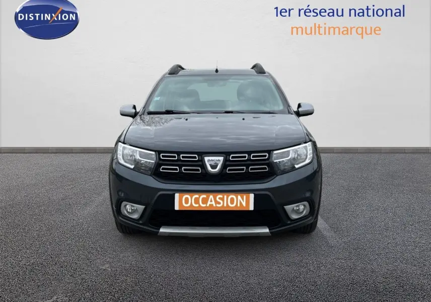 Vue de face d'une Dacia Sandero Stepway gris foncé 2016 avec calandre noire et plaques "OCCASION" visibles.