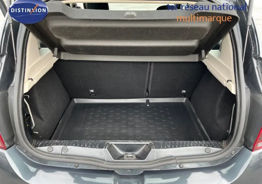 Coffre ouvert vu de l'arrière d'une Dacia Sandero Stepway gris foncé, montrant l'espace de chargement vide.