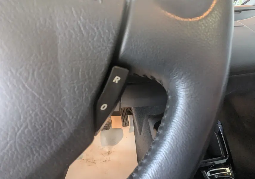 Gros plan sur le volant en cuir noir de la Renault Grand Espace IV, montrant la commande de régulateur de vitesse.