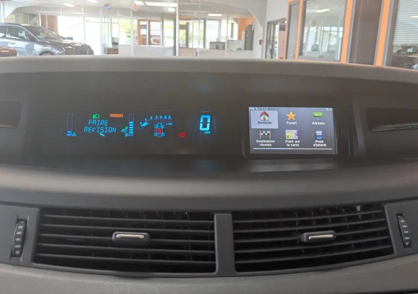 Tableau de bord numérique du Renault Grand Espace IV gris clair, affichant un message de révision et l'écran GPS.