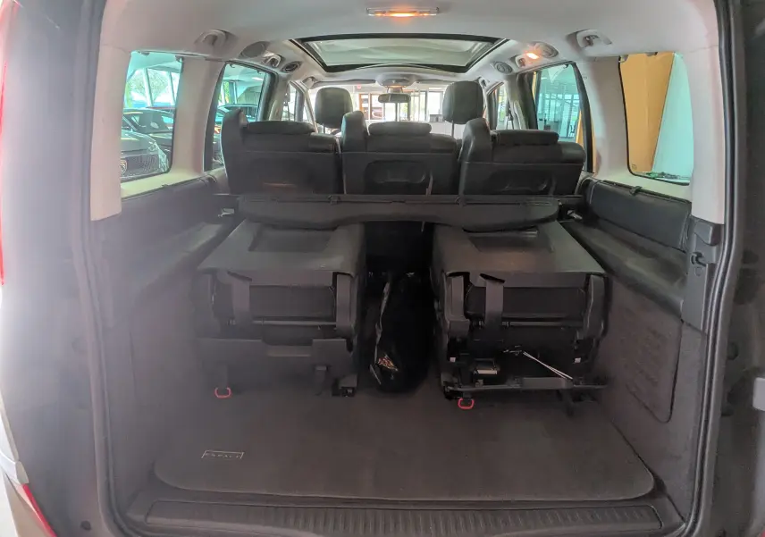 Vue arrière ouverte du coffre du Renault Grand Espace IV gris clair, montrant les sièges arrière rabattus et l'intérieur spacieux.