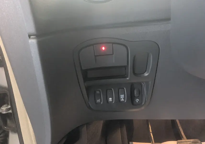 Gros plan sur les commandes situées à gauche du volant dans l’habitacle noir du Renault Grand Espace IV gris clair de 2012.