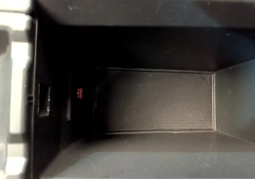 Gros plan sur le compartiment de rangement central intérieur de la BMW Série 1 118i Edition Sport, finition noire.