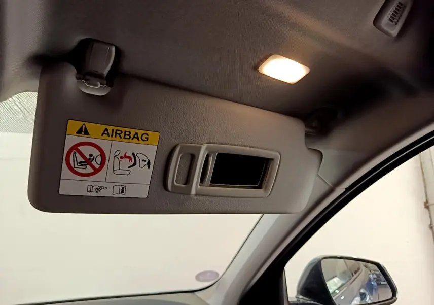 Détail du pare-soleil côté conducteur avec miroir intégré et avertissement airbag dans l’habitacle d’une BMW Série 1.