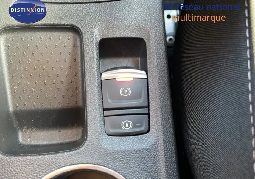 Gros plan sur les commandes de frein à main électronique et arrêt automatique du moteur dans un Renault Symbioz gris cassiopée.