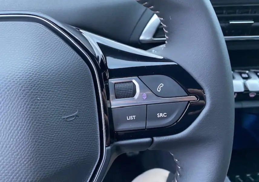 Gros plan sur les commandes gauche du volant noir du Peugeot 5008 2023 avec boutons de gestion audio et appel.