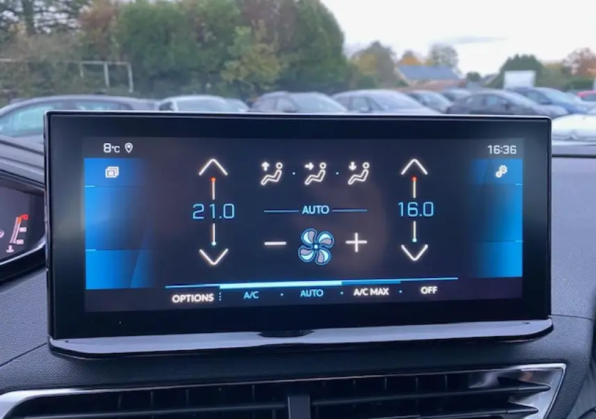 Écran tactile du tableau de bord d’un Peugeot 5008 noir, affichant la climatisation bi-zone en mode automatique.