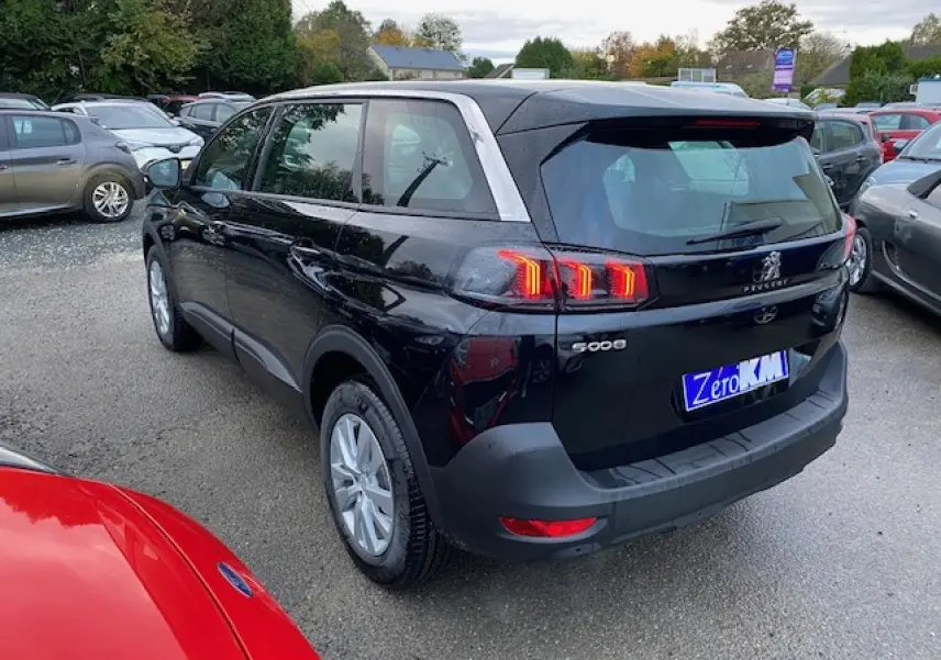 Vue 3/4 arrière droite d’un Peugeot 5008 noir 2023 avec feux arrière LED et jantes alliage 16 pouces.