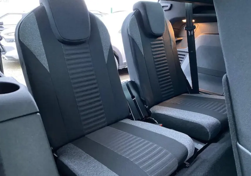 Vue intérieure sur les sièges arrière du Peugeot 5008 2023, tissu noir et gris, avec ceinture de sécurité visible.