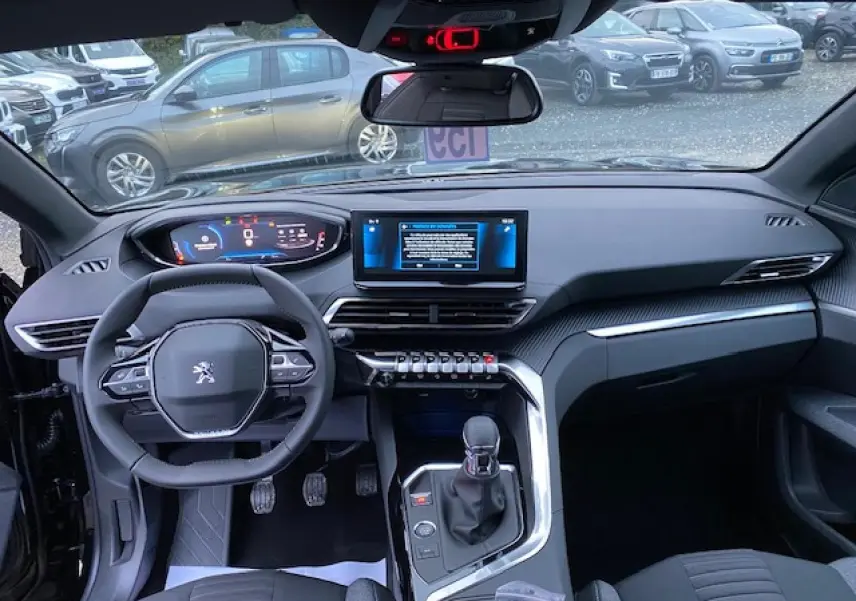 Vue intérieure avant du Peugeot 5008 noir 2023, tableau de bord numérique et écran tactile central visible.