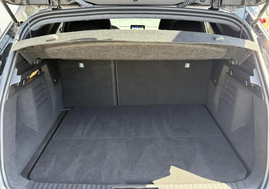 Coffre ouvert vu de l’arrière du Renault SYMBIOZ noir étoilé, montrant un espace de chargement propre et spacieux.