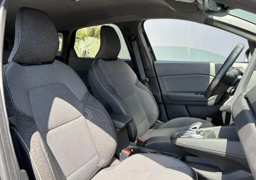 Vue intérieure côté gauche montrant les sièges avant gris foncé et la console centrale du Renault Symbioz E-Tech Full Hybrid 2025.
