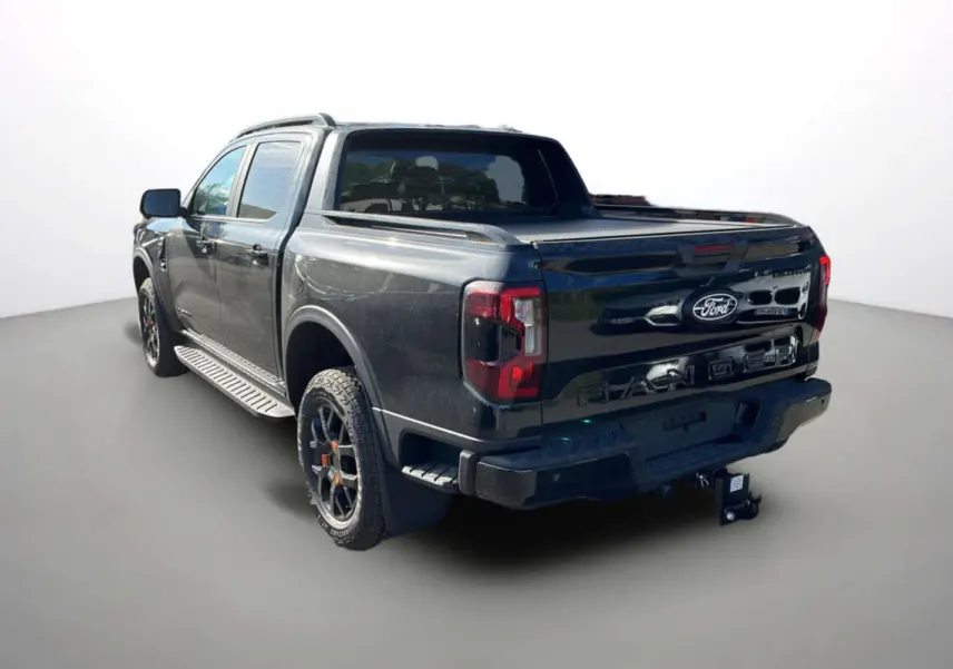 Ford Ranger Wildtrak noir agate vu en 3/4 arrière droit avec benne couverte et jantes tout-terrain.