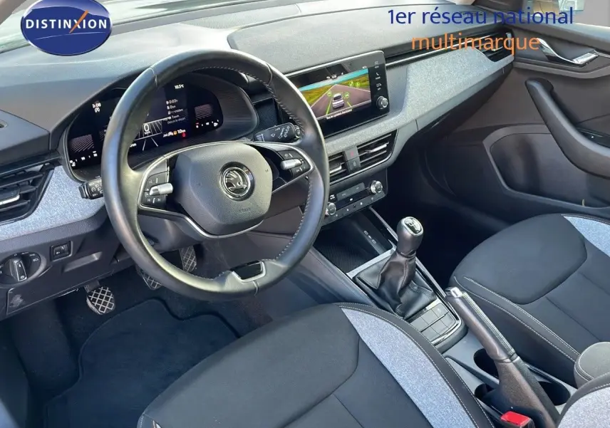 Intérieur avant du Skoda Kamiq 2024 essence gris graphite, volant multifonction, tableau de bord digital et boîte manuelle.