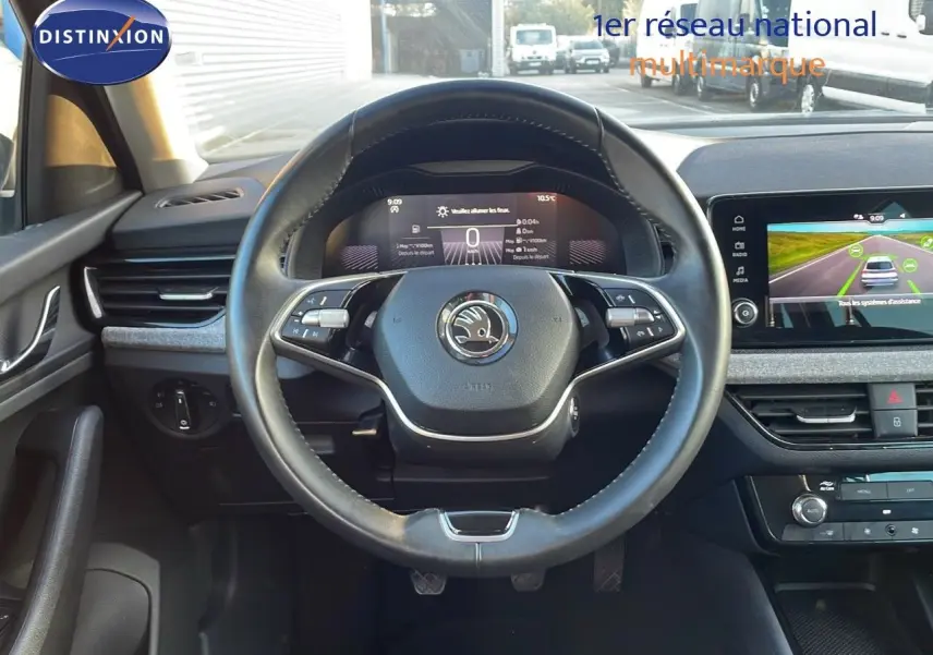 Vue centrée sur le volant et le tableau de bord numérique d'une Skoda Kamiq 2024, intérieur moderne et écran tactile.