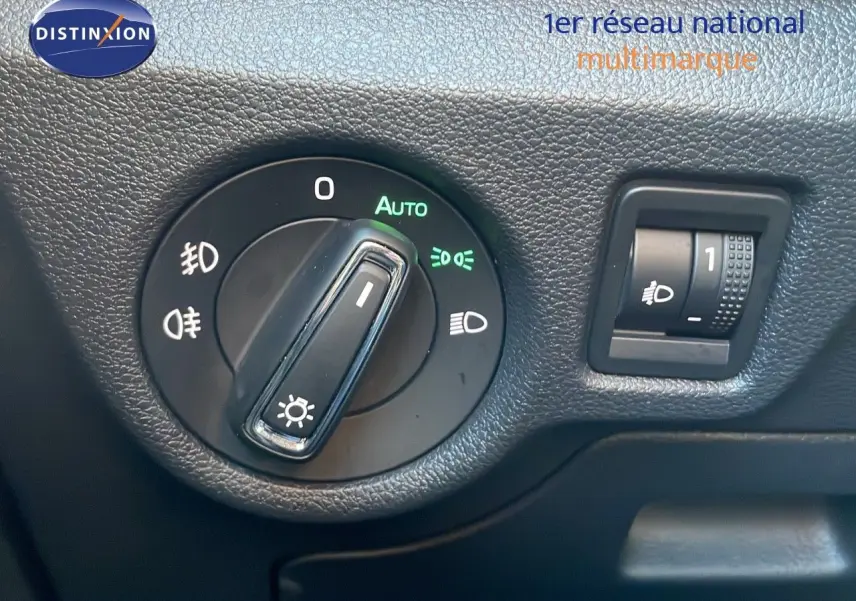 Détail du bouton de commande des phares sur le tableau de bord noir du Skoda Kamiq gris graphite 2024.