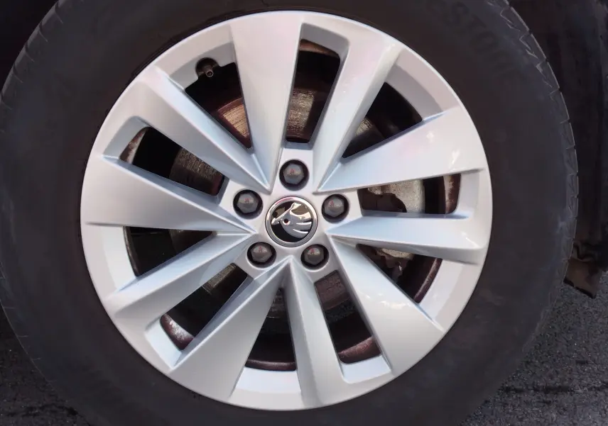 Gros plan sur la jante argentée à 10 branches du Skoda Kamiq 2024, avec logo central noir et blanc visible.