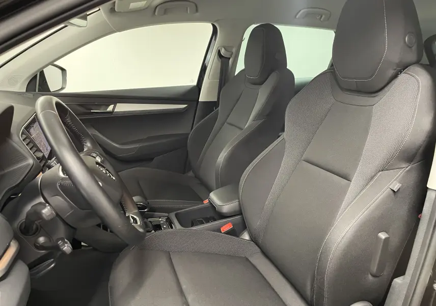 Vue intérieure côté conducteur du Skoda Karoq 2023 avec sièges noirs et tableau de bord digital visible.