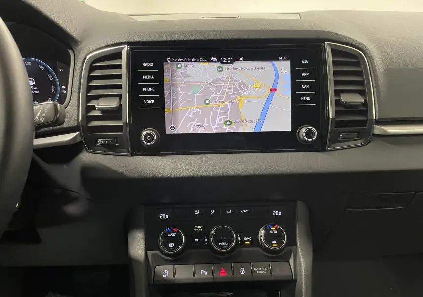Tableau de bord du Skoda Karoq 2023 avec écran tactile central affichant la navigation, finition Business noire.