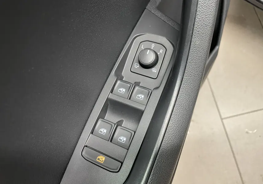 Commandes des vitres et réglage des rétroviseurs côté gauche dans une Skoda Karoq 2023 finition Business noire.