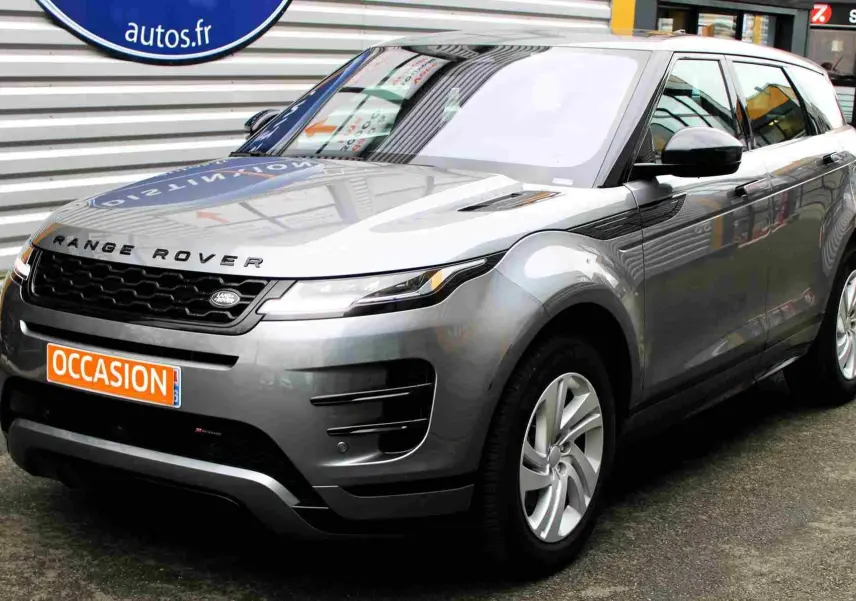 Vue 3/4 avant droit d'un Range Rover Evoque gris métal 2023 avec calandre noire et jantes argentées.