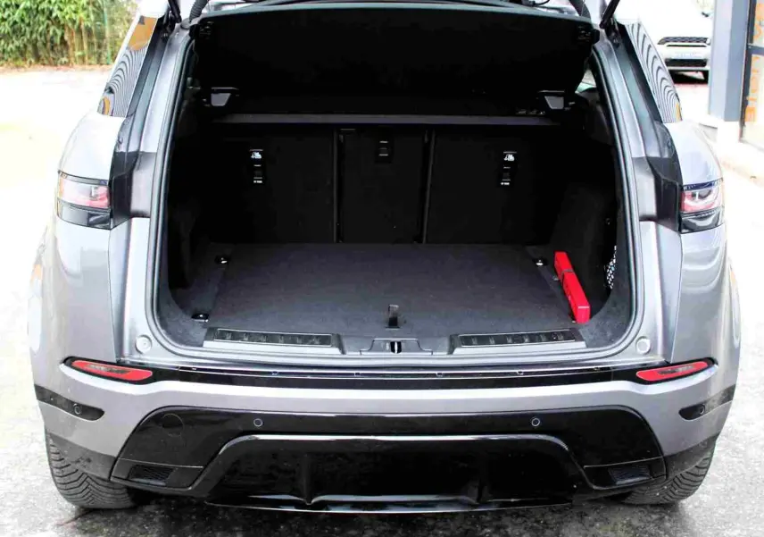 Vue arrière d'un Range Rover Evoque gris métal 2023 avec coffre ouvert et intérieur de coffre vide.
