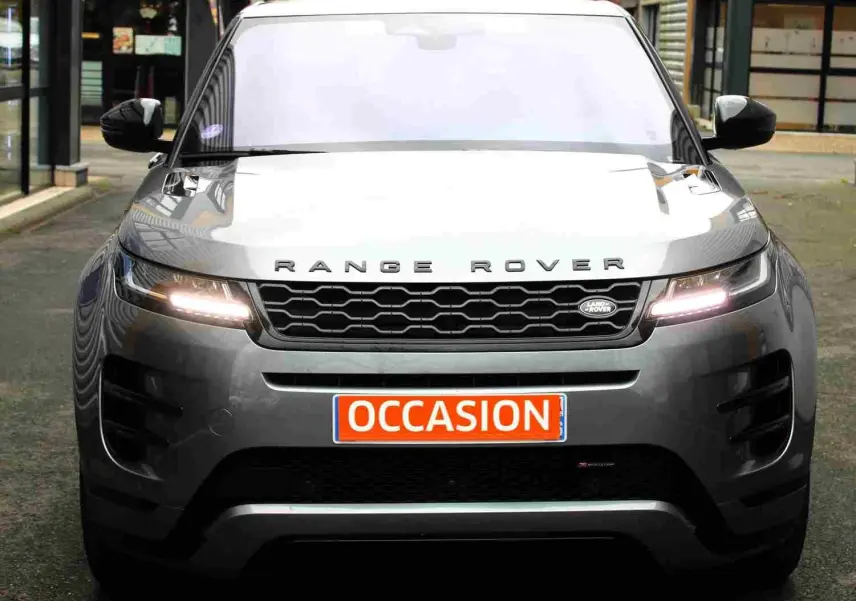 Vue frontale d'un Range Rover Evoque gris métal 2023 avec phares allumés et plaque "OCCASION" visible.