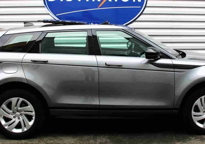 Vue latérale droite d'un Range Rover Evoque gris métal 2023, hybride rechargeable, avec jantes alliage et lignes épurées.