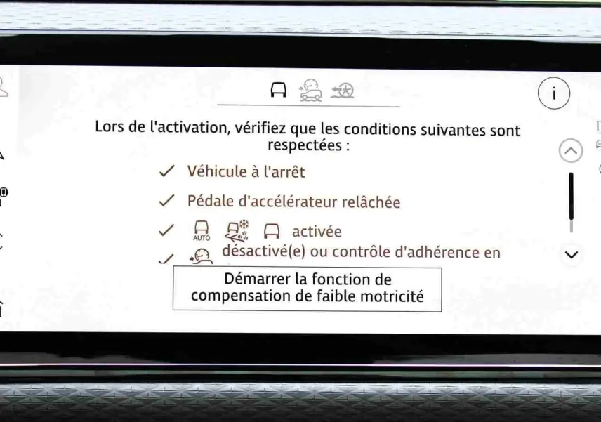 Écran tactile intérieur du Range Rover Evoque 2023 gris métal affichant les conditions d'activation d'une fonction d'aide à la motricité.
