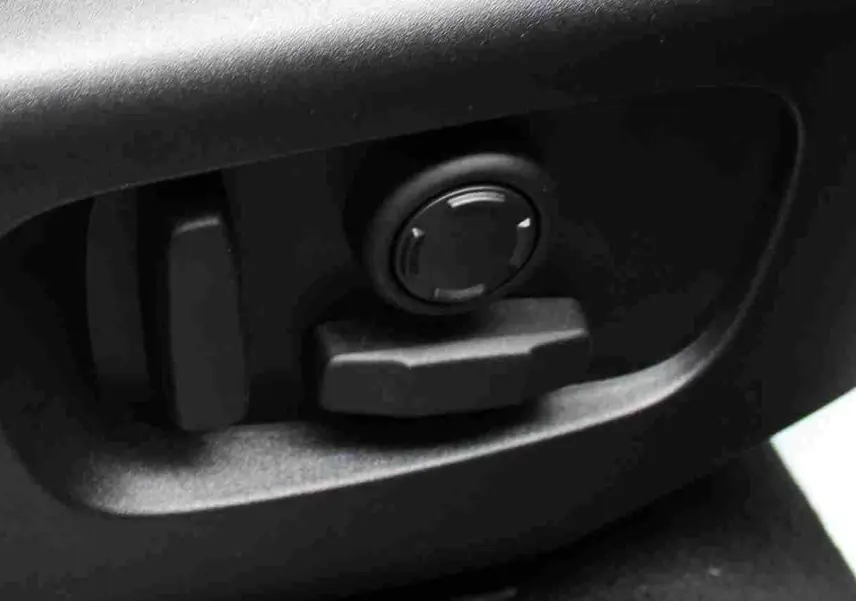 Réglage électrique des sièges en gros plan dans l'habitacle du Range Rover Evoque gris métal 2023.