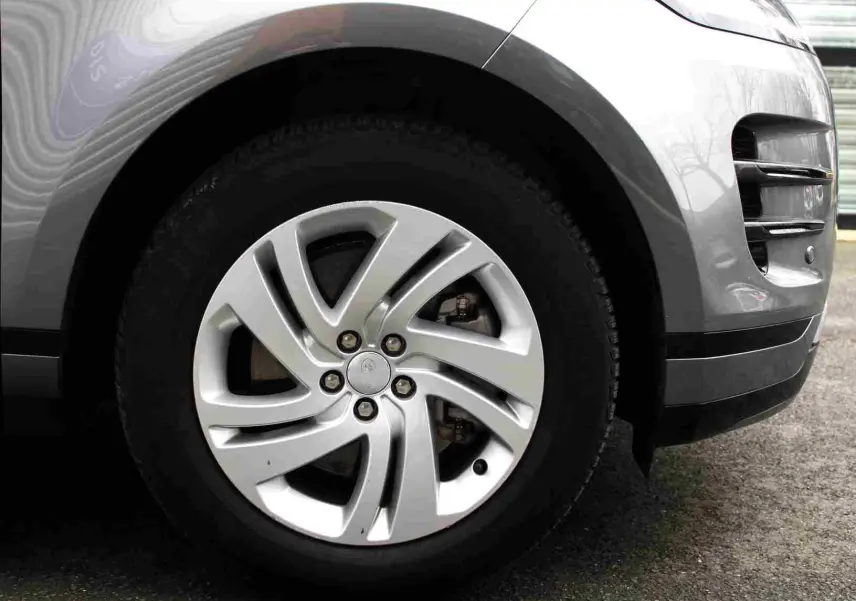 Gros plan sur la roue avant droite gris métal du Range Rover Evoque 2023 avec jante alliage à cinq branches torsadées.
