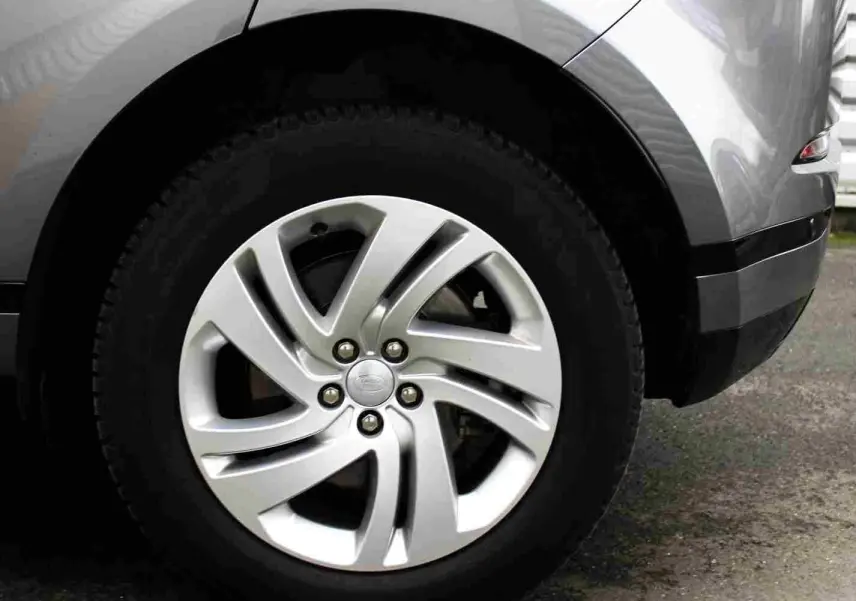 Gros plan sur la roue arrière droite du Range Rover Evoque gris métal 2023, mettant en valeur la jante alliage distinctive.