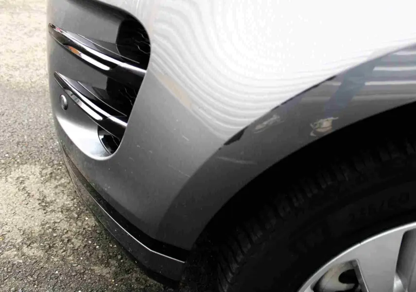 Gros plan sur l'aile avant droite gris métal du Range Rover Evoque 2023 avec prise d'air et partie de la roue visible.