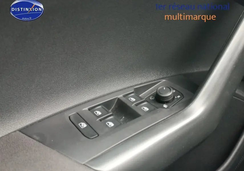 Vue rapprochée du panneau de commandes des vitres et rétroviseurs côté conducteur d'une Volkswagen Polo blanche.