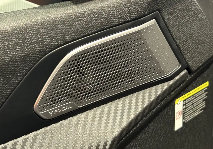 Gros plan sur le haut de la porte intérieure avec haut-parleur Focal et finition carbone dans une Peugeot 508 SW gris Platinium.