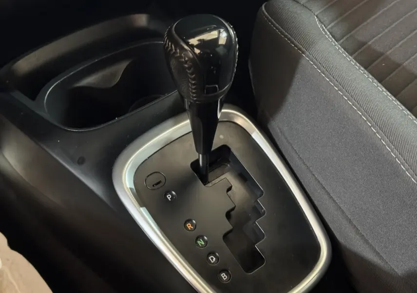 Gros plan sur la commande de boîte automatique noire de la Toyota Yaris hybride 2019, avec siège tissu gris à côté.