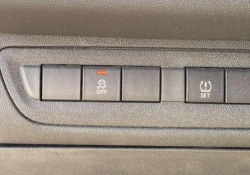 Gros plan sur les boutons de contrôle du tableau de bord d'une Peugeot 208 noire, version Like 2015.