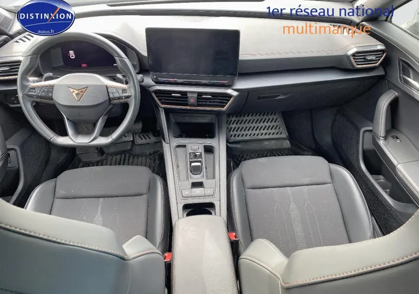 Vue intérieure avant du CUPRA Formentor 2.0 TSI 190 blanc, avec tableau de bord moderne et sièges noirs sport.