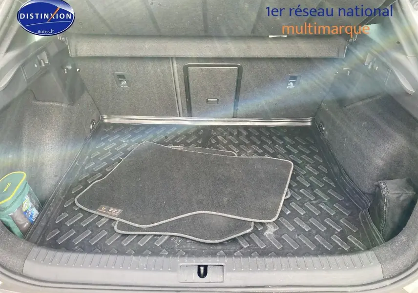 Coffre ouvert vu de l'arrière d'une CUPRA Formentor blanc avec tapis de sol noirs et rangement organisé.