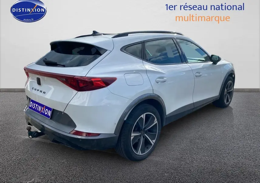 Vue 3/4 arrière droite du CUPRA Formentor blanc 2023 avec jantes alu noires et attelage visible.