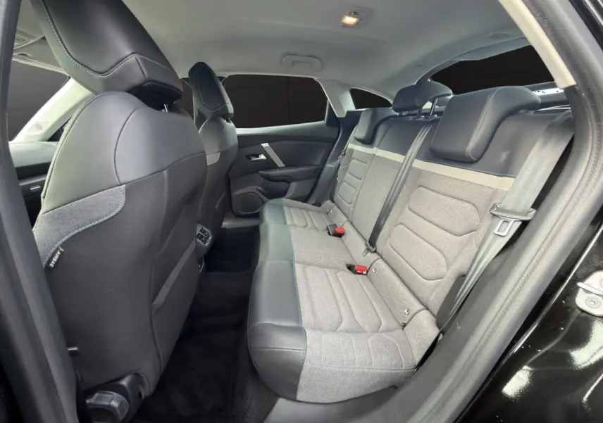Intérieur arrière de la Citroën C4 2023 noir, vue côté droit montrant la banquette bi-matière gris et noir avec appuie-têtes.